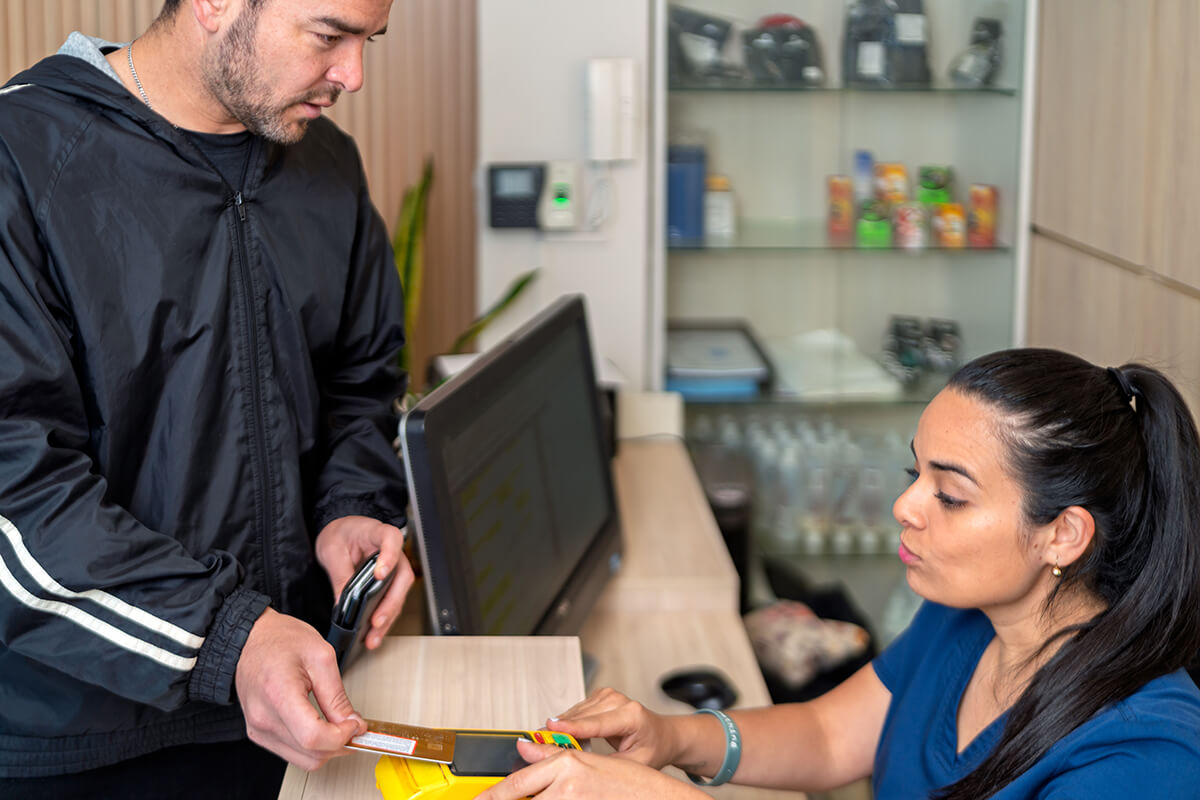 Client paying for wellness services at reception desk